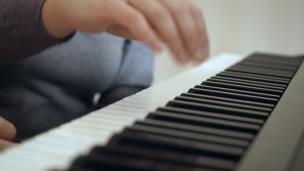 Mujer joven enseña a niña a tocar el piano . — Vídeos de Stock