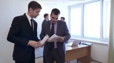 Meslektaşı ile işadamı belgeleri ile standları ve tartışmak.