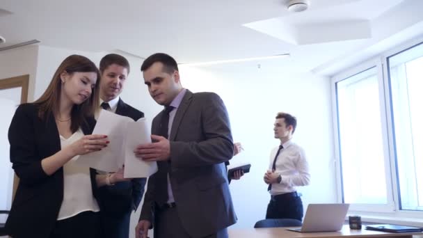 Бизнесмены с коллегой-женщиной стоят с документами в офисе . — стоковое видео