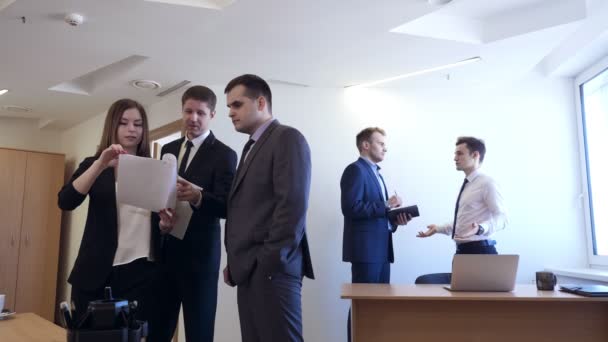 Geschäftsmann mit Kollegin steht mit Unterlagen im Büro. — Stockvideo