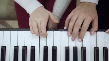 Elektrikli piyano çalan küçük kız ile öğretmen üst görünümü.