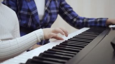Piyanoda çalan çocuk ellerine yakın çekim görünüm.