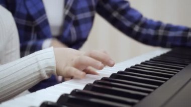Piyanoda çalan çocuk ellerine yakın çekim görünüm.