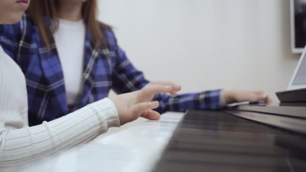 Fiatal tanár kis aranyos lány játszik az elektromos zongora. — Stock videók