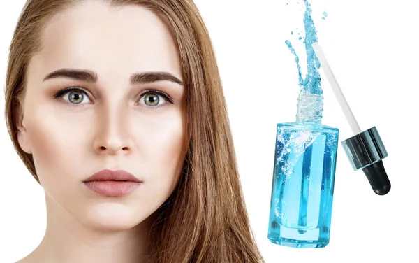 Krásná tvář mladé ženy blízko modré kosmetické láhve. — Stock fotografie
