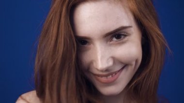 Redhead kadın poz ve kamera da gülümseyen yakın çekim görünümü.
