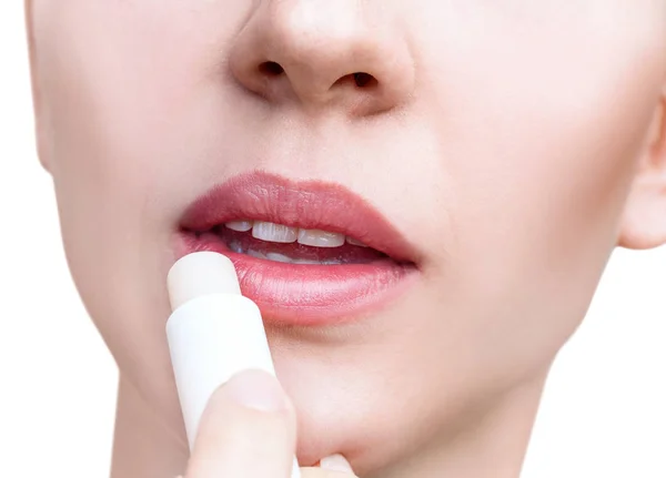 Молода жінка наносить бальзам на губи. Концепція догляду за губами . — стокове фото