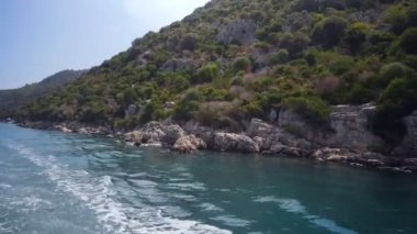 Tekneden bak. Tekne kıyıya yakın yüzüyor..