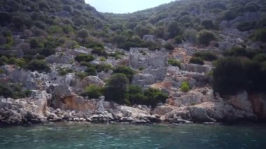 Denizde yüzen tekneden Kekova harabeleri görünümü.