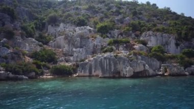 Denizde yüzen tekneden Kekova harabeleri görünümü.