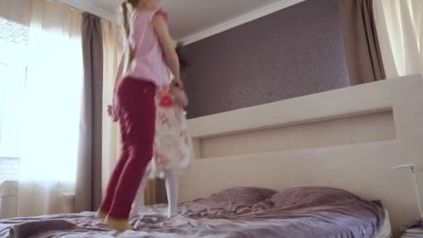 Dwie małe dziewczynki, skoki na łóżku. — Wideo stockowe