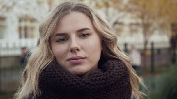 Чудова молода блондинка у великому в'язаному шарфі на відкритому повітрі . — стокове відео