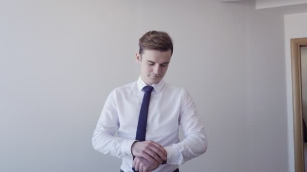 Молодой бизнесмен регулирует наручные часы и показывает большой палец вверх жестом — стоковое видео