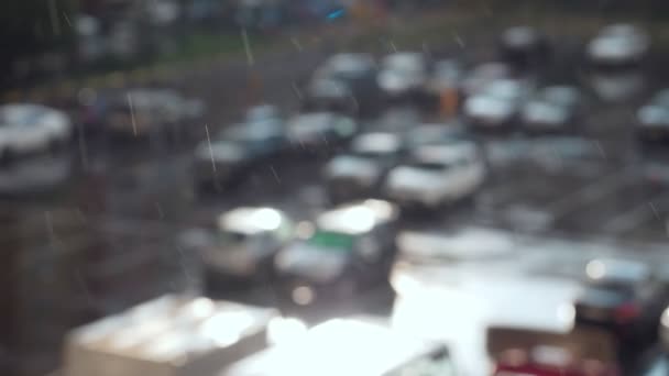Regentropfen fallen auf den Parkplatz für Autos. verschwommener Hintergrund. — Stockvideo