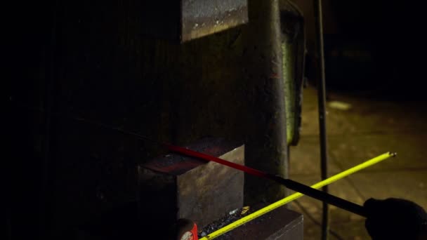 Blacksmith holding candent iron ingot and forging it using pneumatic hammer. — Stock Video