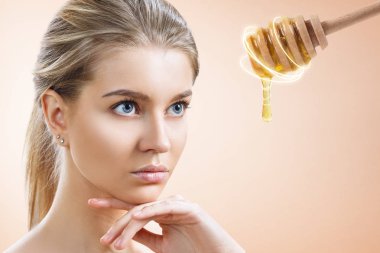 Genç kadın ve bal kaşığı yüz maskesi hazırlamak.