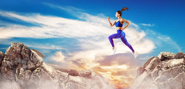 Sporty woman jump through the gap between hills over sky background. — Stock Photo, Image