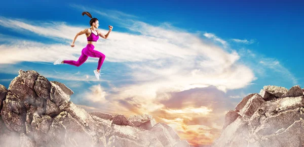 Gökyüzü arka planda tepeler arasındaki boşluk üzerinden sportif kadın atlamak. — Stok fotoğraf