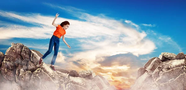 Redhead woman falling down between hills on cliff. — Stock Photo, Image