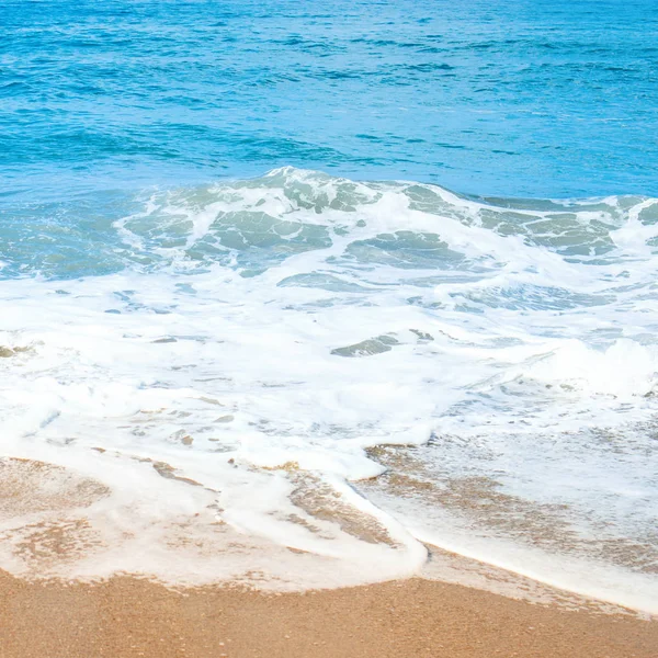 Praia de areia e suave onda azul do oceano com espuma de whie . — Fotografia de Stock