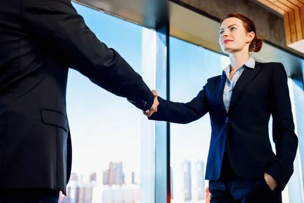 屋内で握手をする正式なスーツを着たプロのビジネスウーマンと男性. — ストック写真