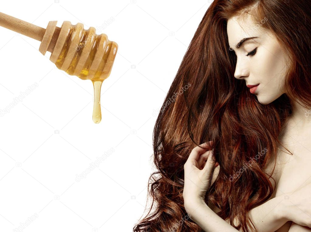 Woman with honey spoon prepare for hair mask.