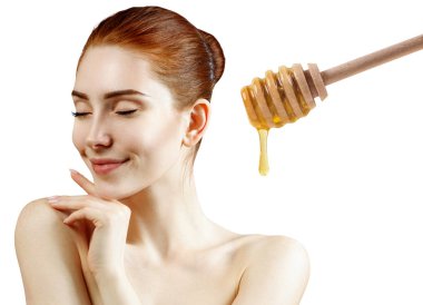 Genç Redhead kadın ve bal kaşığı yüz maskesi hazırlamak.