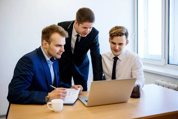 Colleagues sitting at the desk and discuss work. — Stock Photo, Image