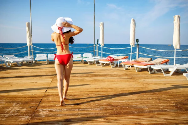 Young woman in swimwear standing on the wooden beach pier. — Stock Photo, Image