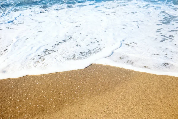 Praia de areia e suave onda azul oceano com espuma branca . — Fotografia de Stock