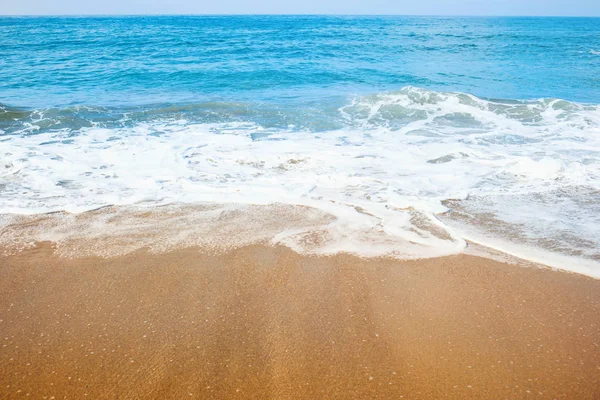 Praia de areia e suave onda azul do oceano com espuma de whie . — Fotografia de Stock