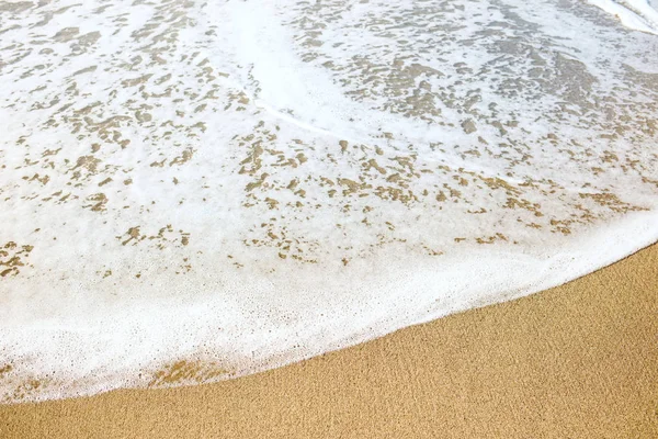 Spiaggia sabbiosa e morbida onda blu oceano con schiuma bianca . — Foto Stock