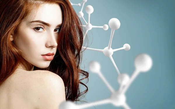 Gyönyörű redehead nő közelében nagy fehér molekula szerkezete. — Stock Fotó
