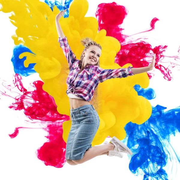 快乐的女人跳过油漆爆炸背景. — 图库照片