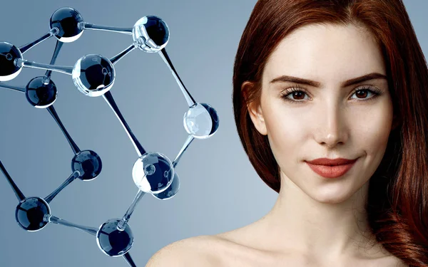 Beautiful redehead woman near big white molecule structure. — Stock Photo, Image