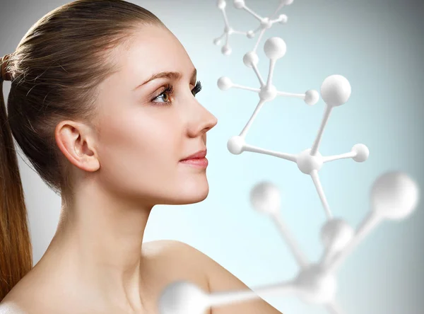 Beautiful woman near big white molecule structure. — Stock Photo, Image