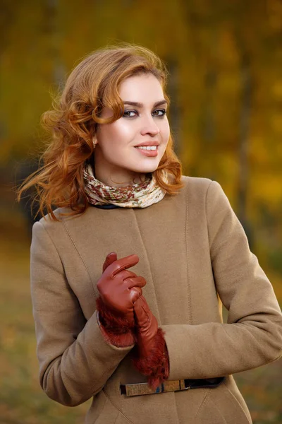 Stylowa Kobieta w beżowej sierści i rękawiczkach stojących w jesiennym żółtym parku. — Zdjęcie stockowe
