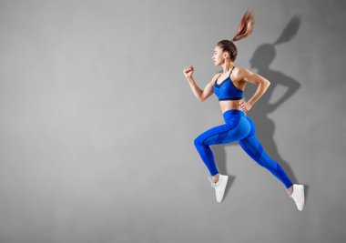 Havada mavi spor giyim atlama genç kadın Runner.