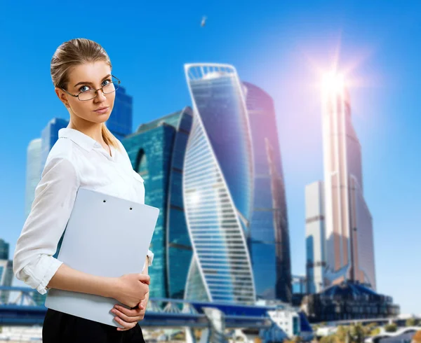 Geschäftsfrau mit Klemmbrett über Stadtbild-Hintergrund. — Stockfoto