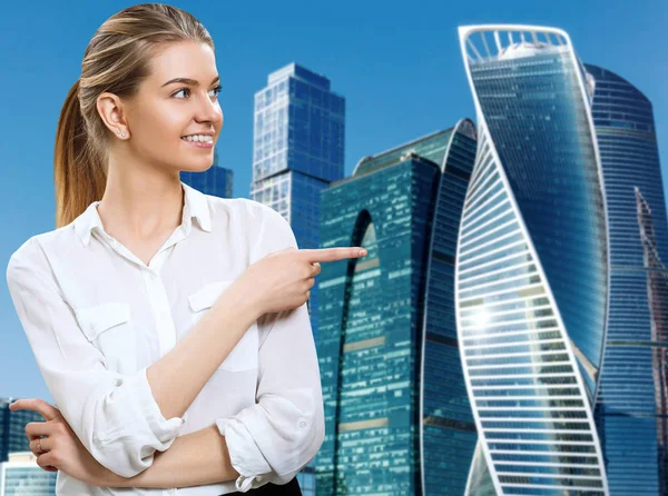 Affärskvinna pekar med fingret åt sidan över stadsbilden bakgrund. — Stockfoto