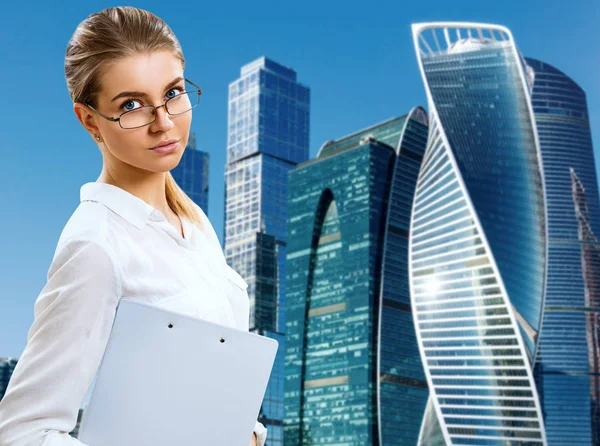 Geschäftsfrau mit Klemmbrett über Stadtbild-Hintergrund. — Stockfoto