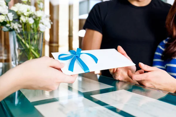 Receptionist woman gives certificate to visit of spa salon. — Stock Photo, Image