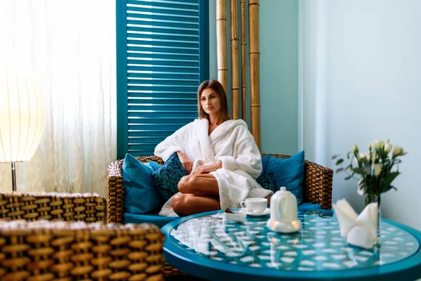 Woman in bathrobe drinking tea in spa salon. — Stock Photo, Image