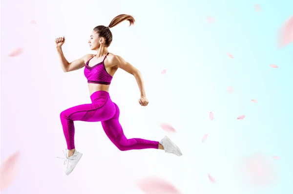 Young woman runner in purple sportswear jump in the air. — Stock Photo, Image