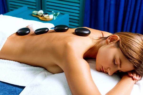 Tajski terapeuta robi masaż gorącymi kamieniami. — Zdjęcie stockowe