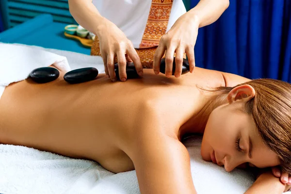 Thai therapist doing massage with hot stones. — Stock Photo, Image