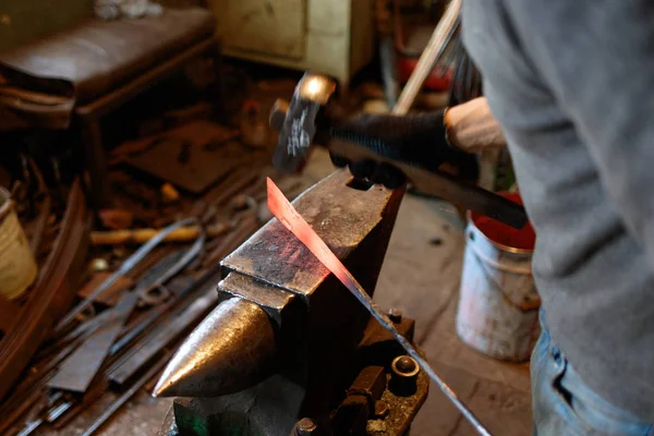 Herrero forjando metal rojo-caliente con martillo . — Foto de Stock