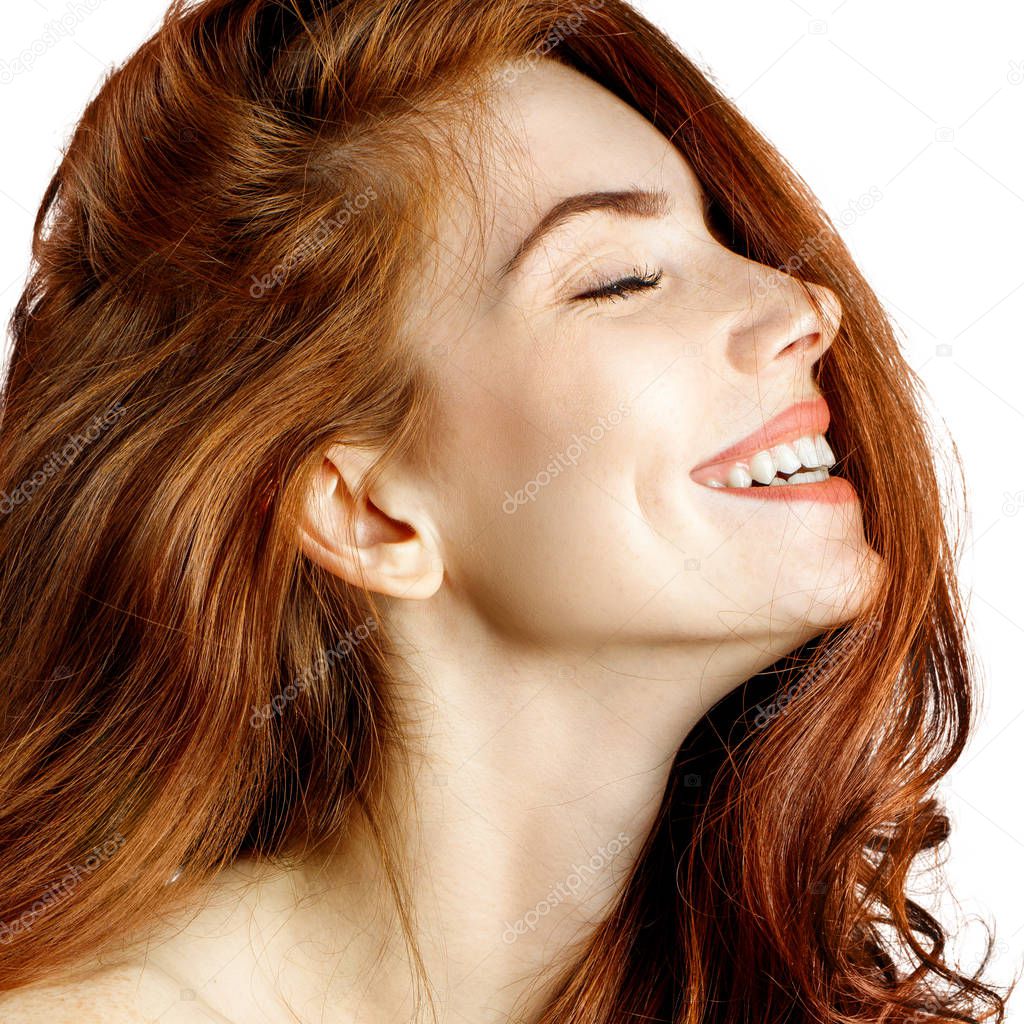 Beauty portrait of redhead woman laughs with closed eyes.