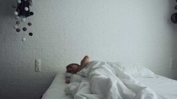 Kvinna uppvaknande i bekväm mysig säng stretching och stiger upp. — Stockvideo