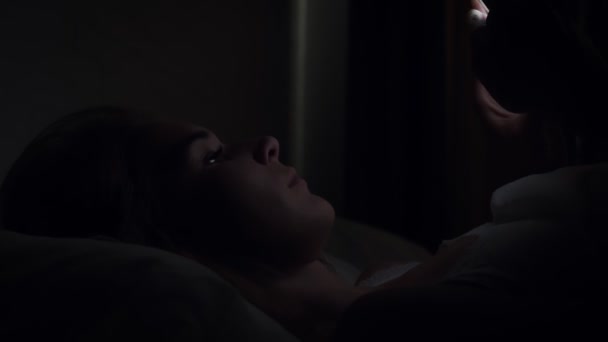 Mulher usando smartphone na cama antes de dormir à noite . — Vídeo de Stock